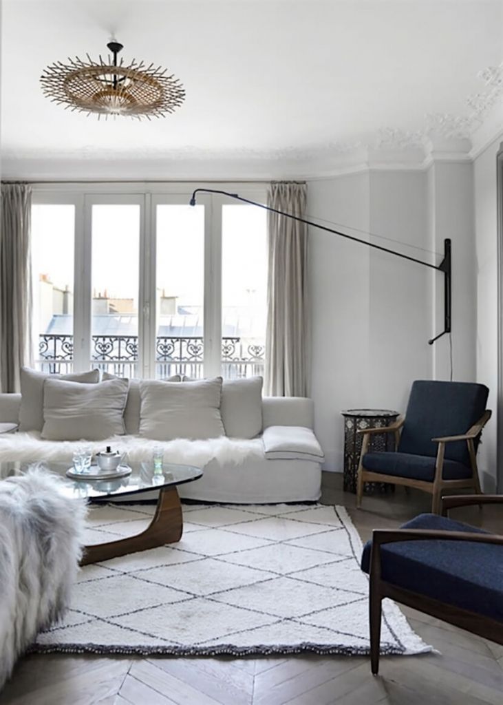 Zona de estar moderna y minimalista con sofá blanco y butacas azules
